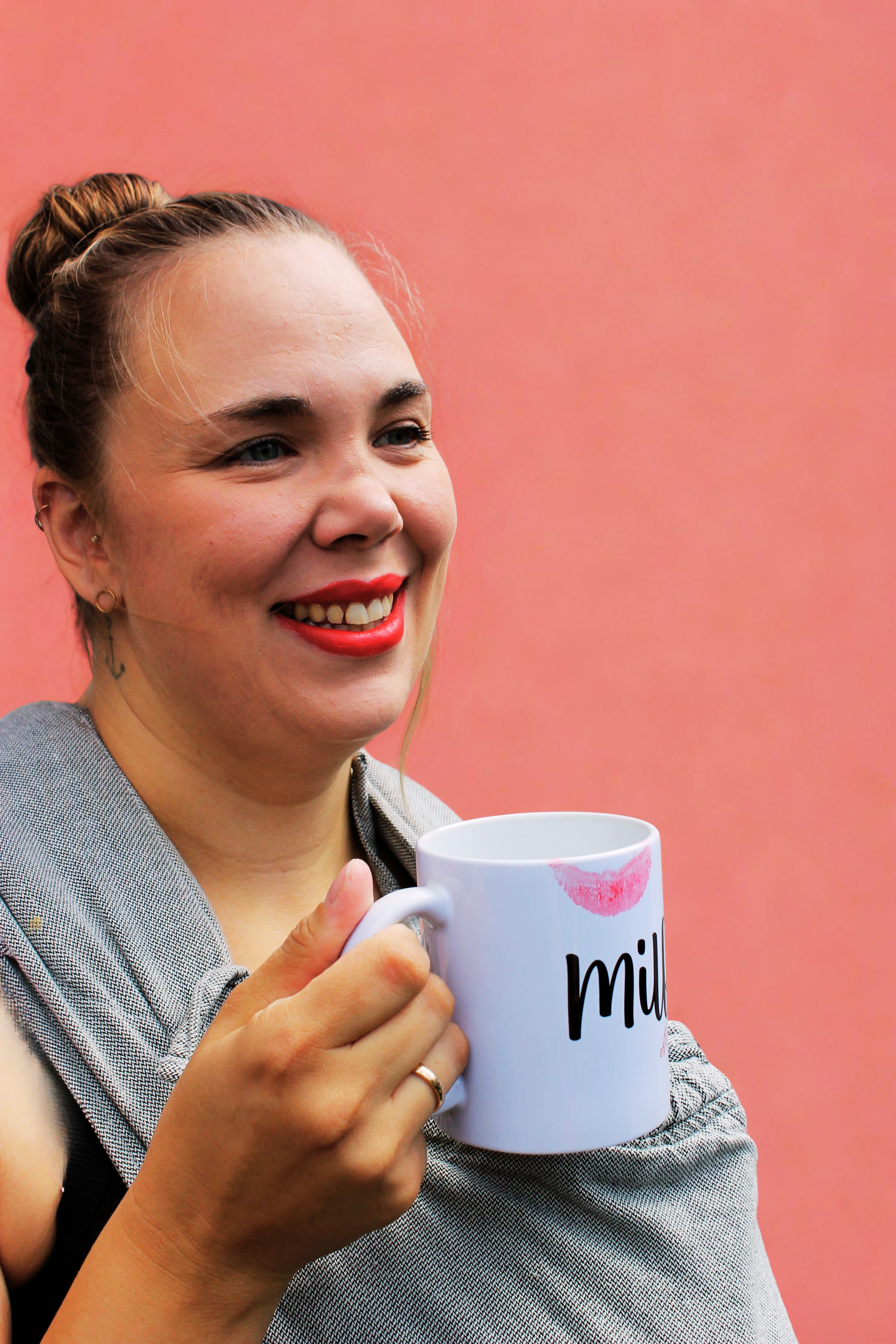 Lisa mit einer Tasse in der Hand, entspannt lächelnd